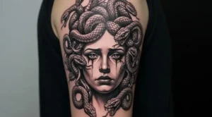 Detailed Medusa tattoo design showing realistic snake hair, mythological face, and black and grey shading on arm placement.