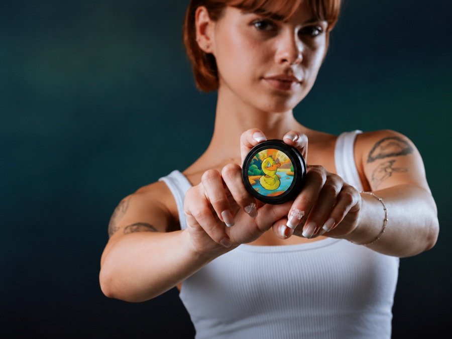 Woman holding an Inky Duck tattoo aftercare balm tin