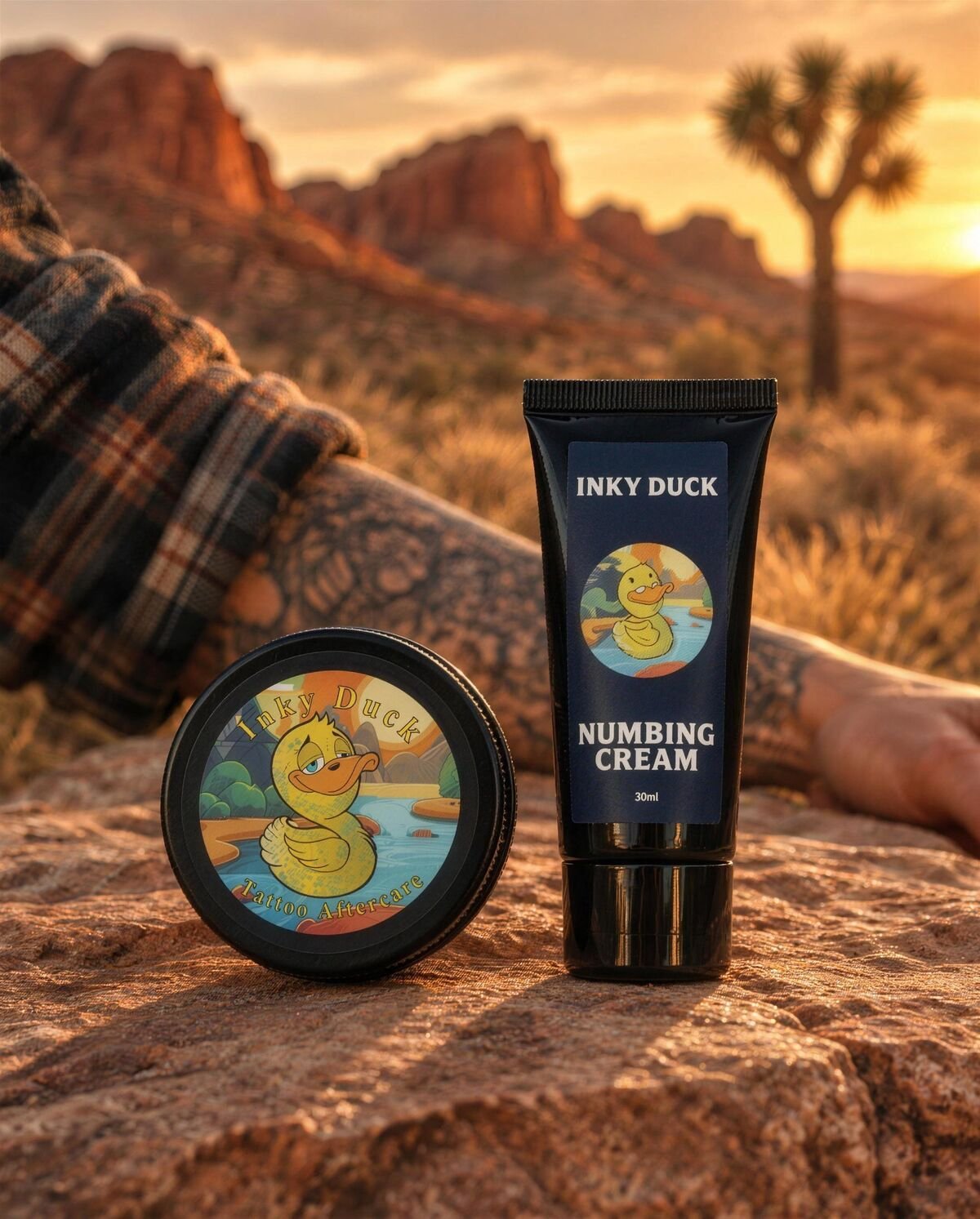 Inky Duck Tattoo Aftercare Balm and Inky Duck Numbing Cream on red rock at sunset in the Nevada desert